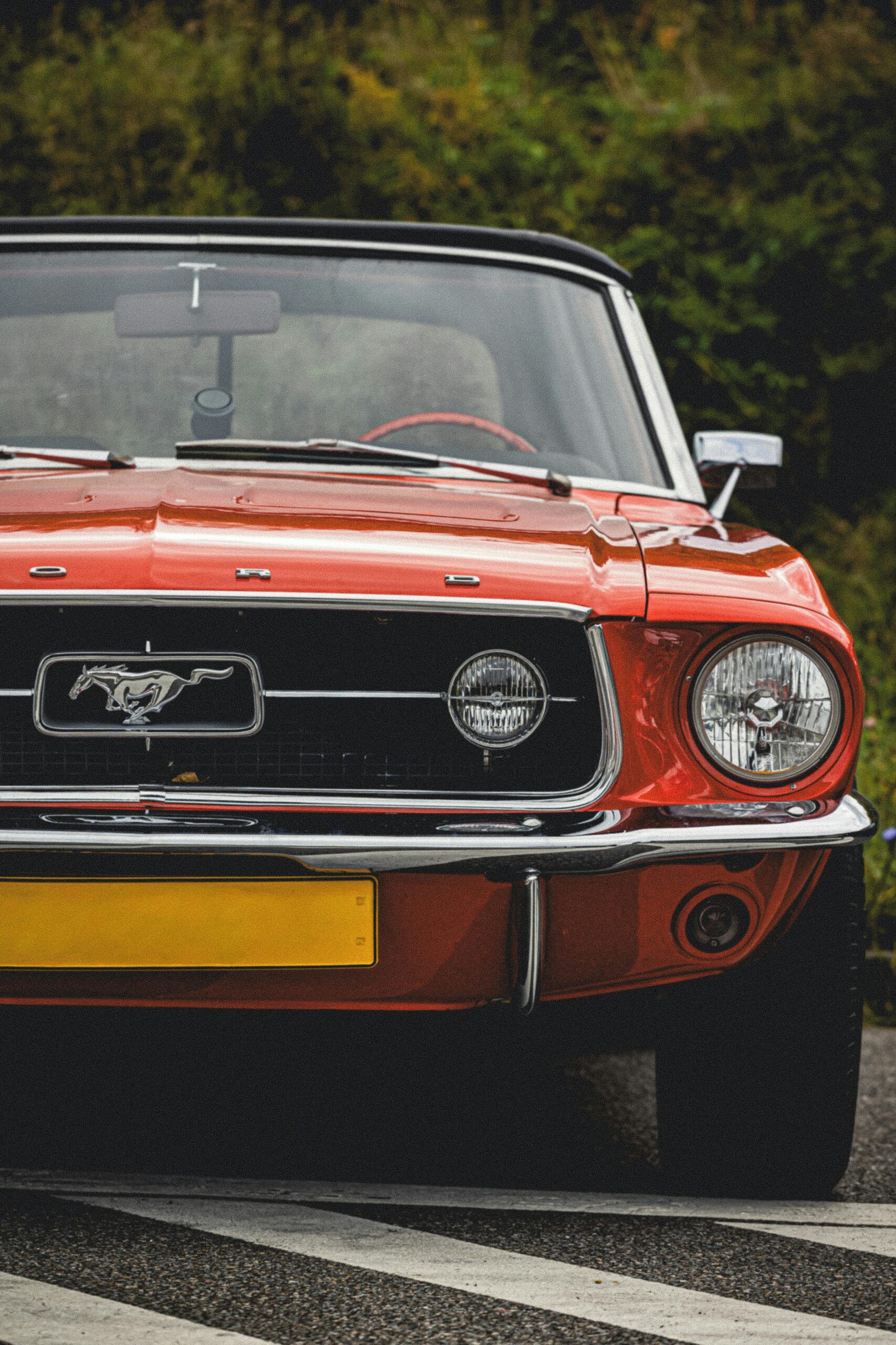 Vintage red Ford Mustang captured outdoors highlighting its design under a clear sky.
